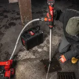 The M12™ HYDROPASS™ M12-BSWP water pump actively pumping water from a flooded trench, demonstrating its effectiveness in draining large volumes.
